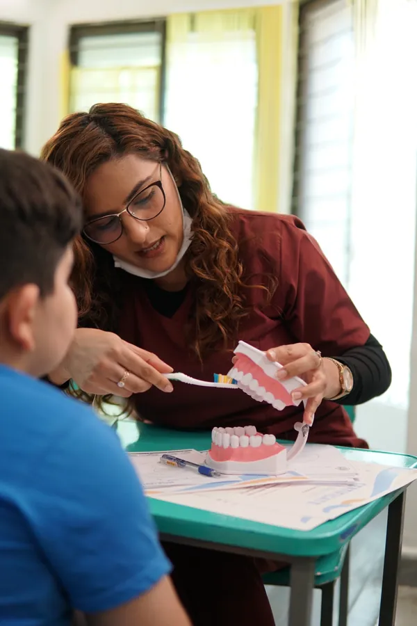 Dentist teaching a child proper tooth brushing using a dental model at Smile Center Islamabad